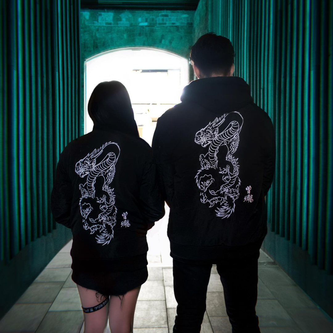Japanese retro fashion brand dragon embroidered jacket men's women's autumn winter bomber jacket work wear casual. View of couple female and male model with back of jacket facing the camera.