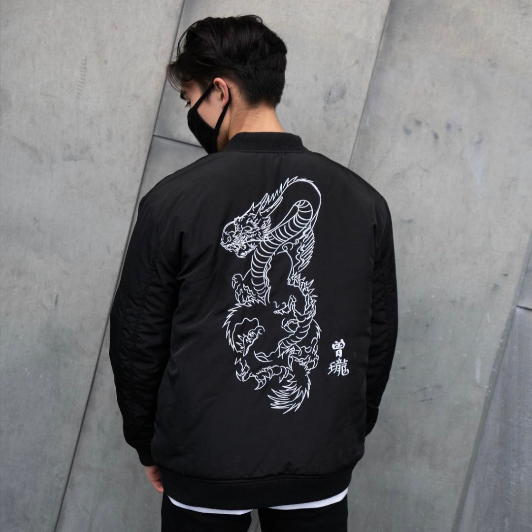 Japanese retro fashion brand dragon embroidered jacket men's women's autumn winter bomber jacket work wear casual. View of male model wearing jacket with back to camera.