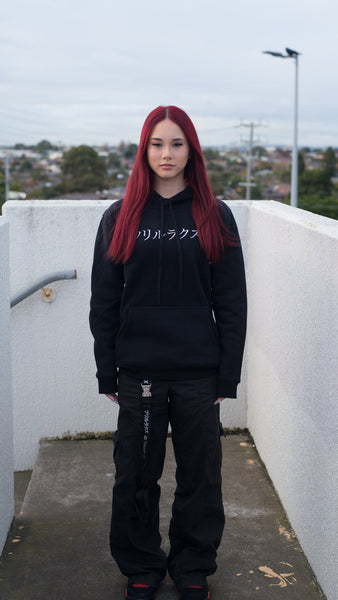 Bold and fearless, a woman confidently wears the Trillax Black Oni Hoodie, expressing her unique style and making a bold fashion statement