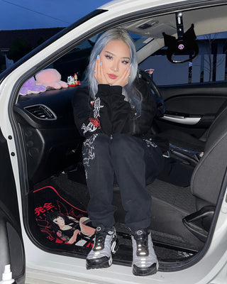 Passenger princess: A girl sits in her car, showcasing her Kuromi Tsurikawa hanging on the car handle. Kuromi lovingly accompanies her on every journey, adding a touch of charm to her travels